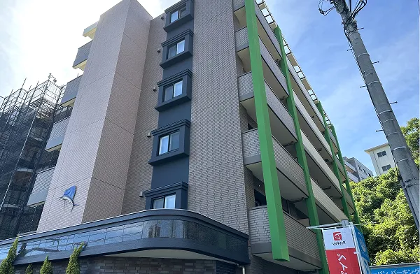 外壁が清潔感のあるベージュとグリーンに塗り替えられ明るく現代的な印象に変化したマンション