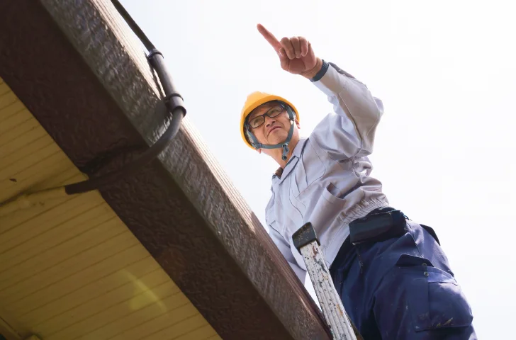 屋根の上で作業をしているスタッフ